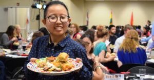 Student displaying plate of food at International Dinner event