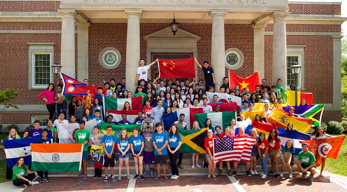 Students holding up colorful flags from around the world